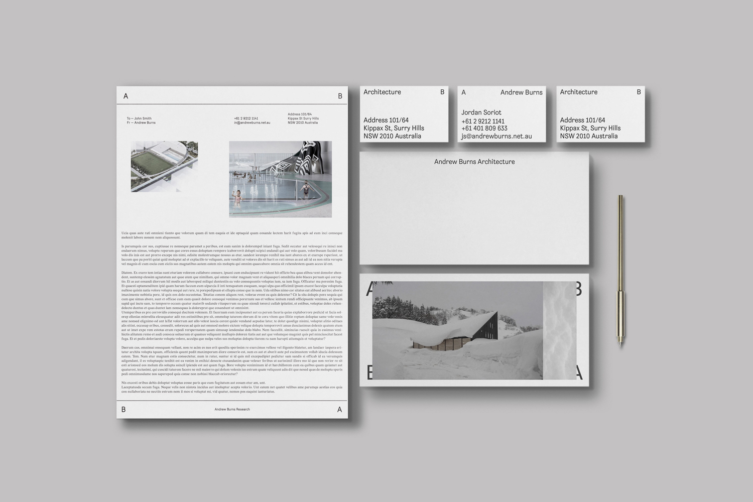 Flat lay of corporate identity stationery including letterhead, business cards, and a sleek pen on grey background