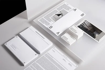 Minimalist brand identity stationery set with white envelopes, letterhead, and business cards on a clean surface.