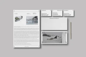 Flat lay of corporate identity stationery including letterhead, business cards, and a sleek pen on grey background