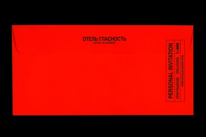 Vibrant red envelope with black typography against a dark background for Hotel Glasnost brand identity