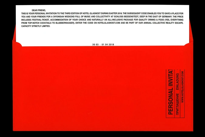 Bright red open envelope containing a white invitation letter with bold black printed text against a dark background