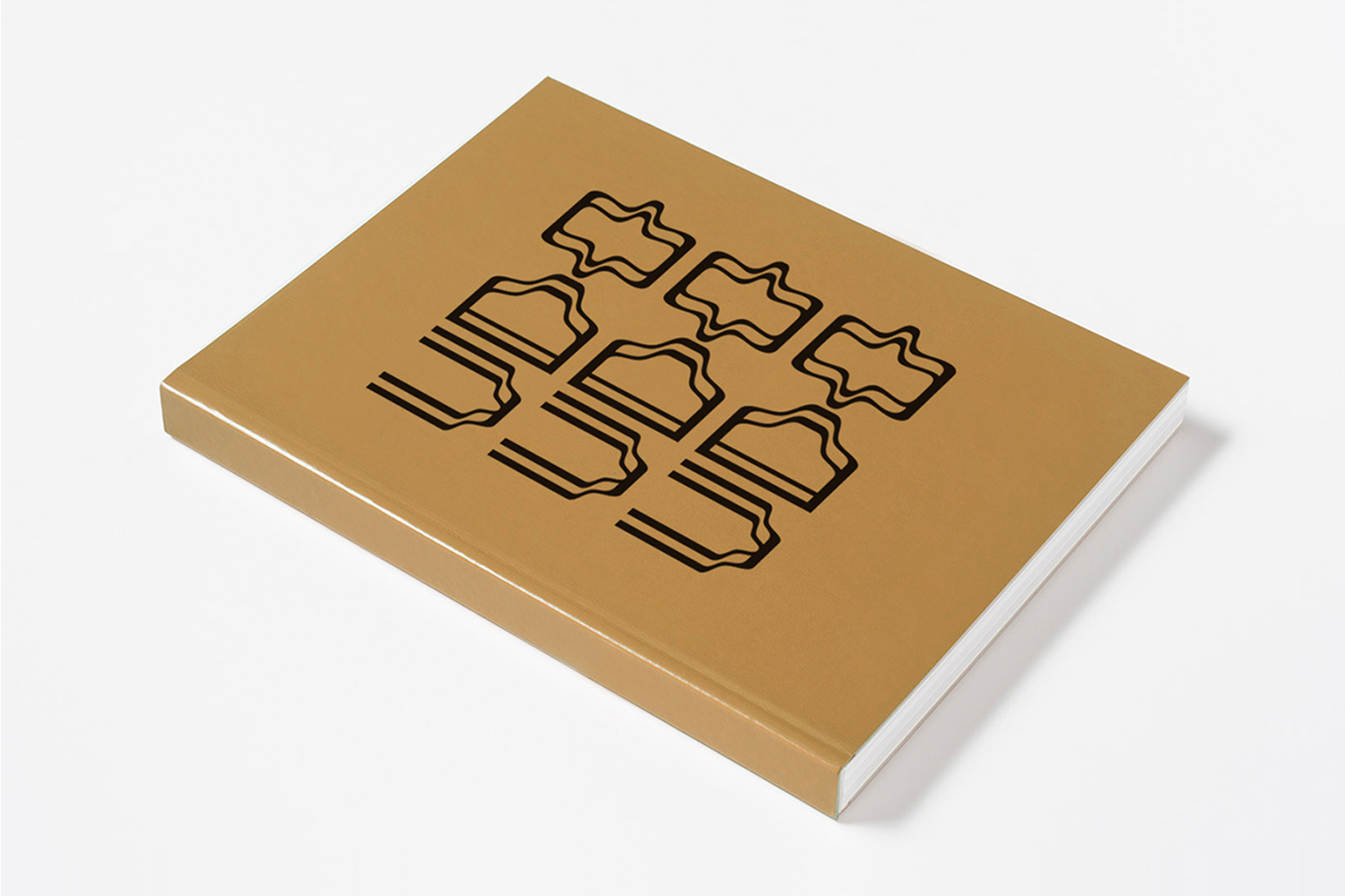 Tan book with black abstract graphic design on cover resting on a plain white background