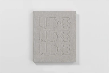 Grey linen-textured book with debossed typography on the cover against a plain white background