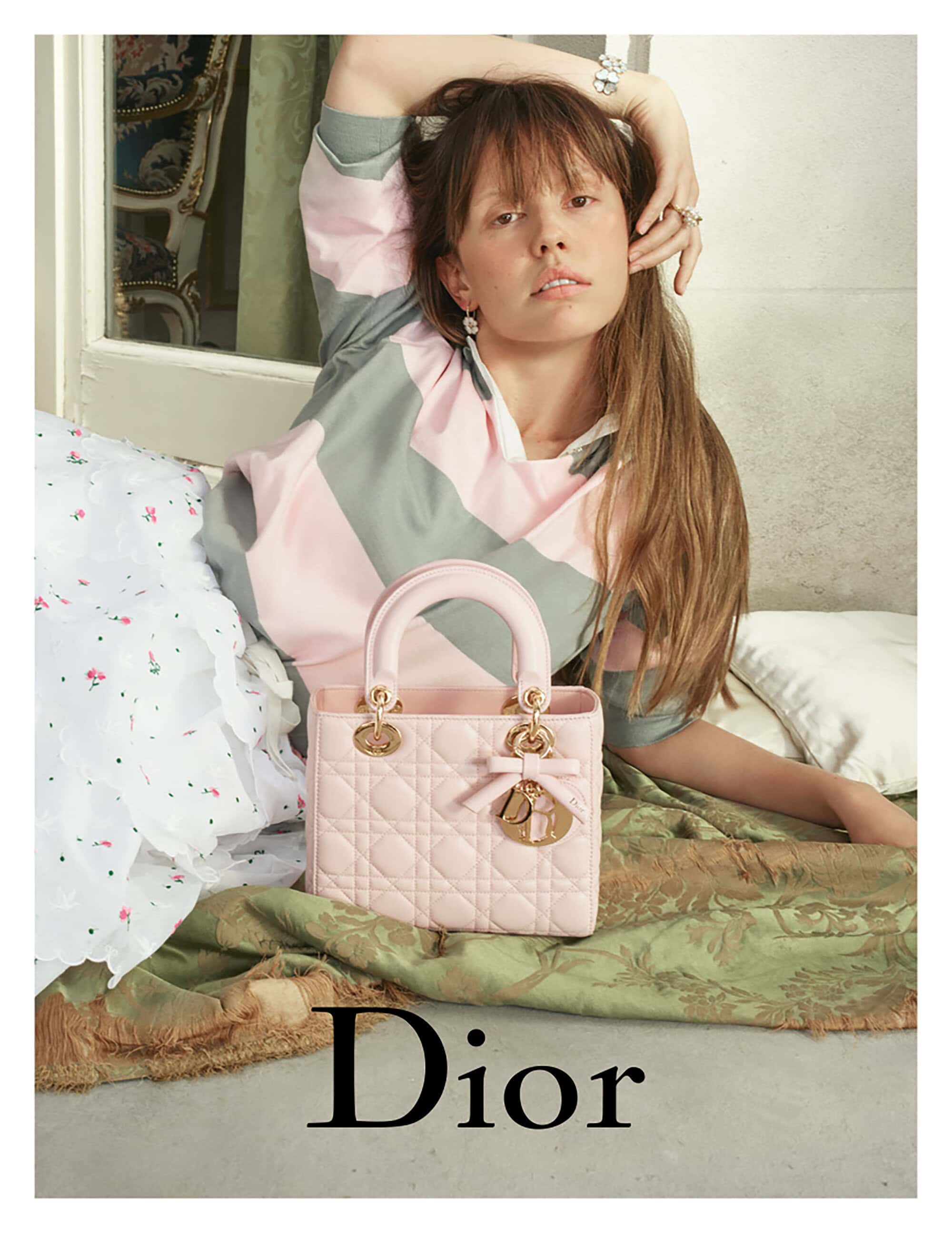 Model Mia Goth posing with a pink Lady Dior handbag for the 2025 campaign photographed by David Sims