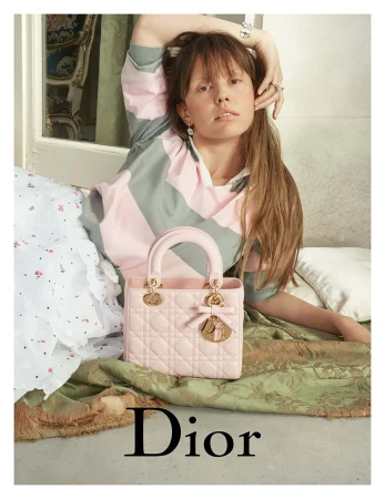 Model Mia Goth posing with a pink Lady Dior handbag for the 2025 campaign photographed by David Sims