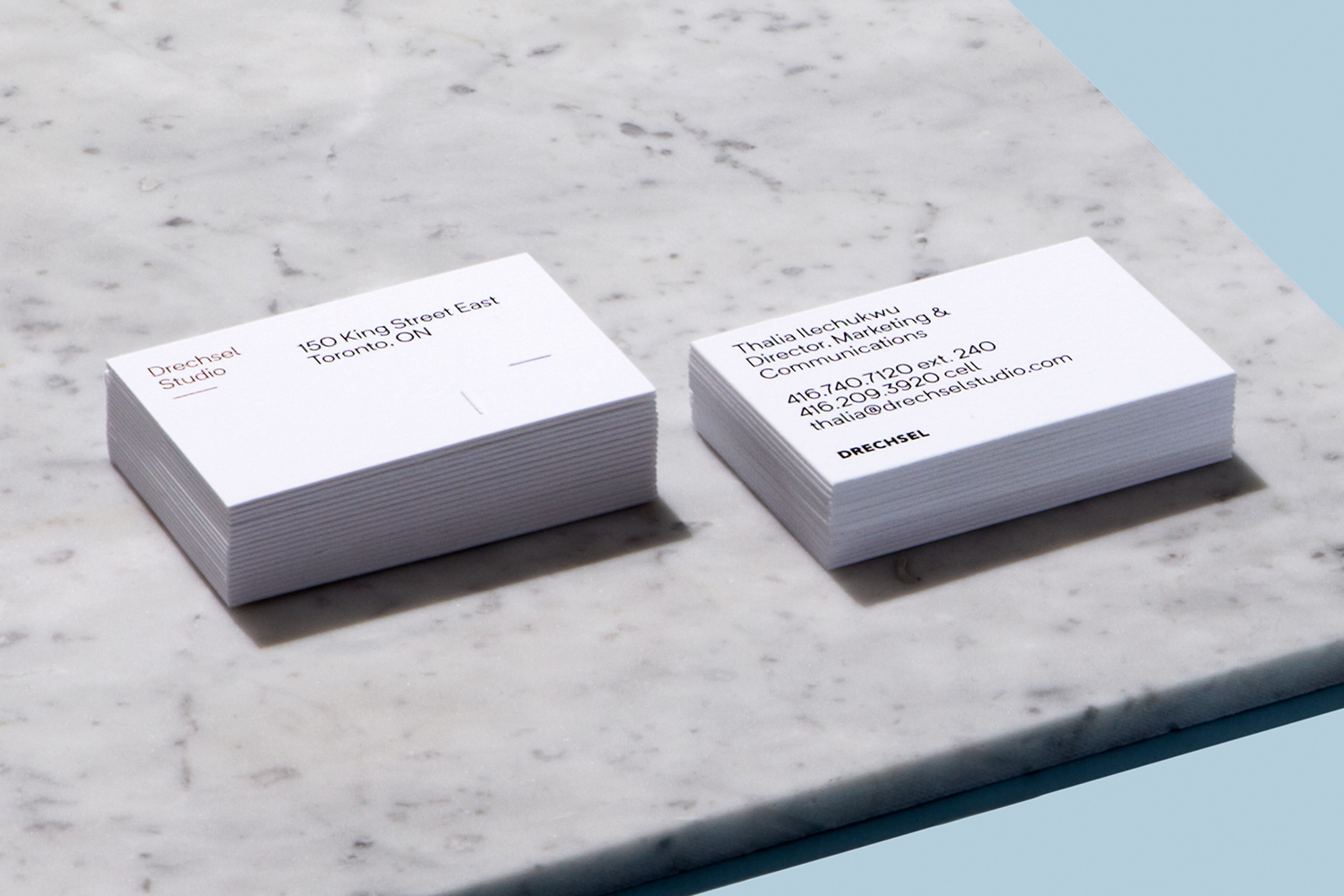 Two stacks of white business cards resting on a marble surface, featuring minimalist typography for Drechsel brand identity.