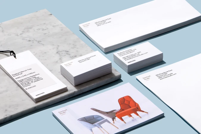 Branded stationery set for Drechsel by Underline Studio featuring business cards, envelopes, product tags, and a brochure on blue surface.