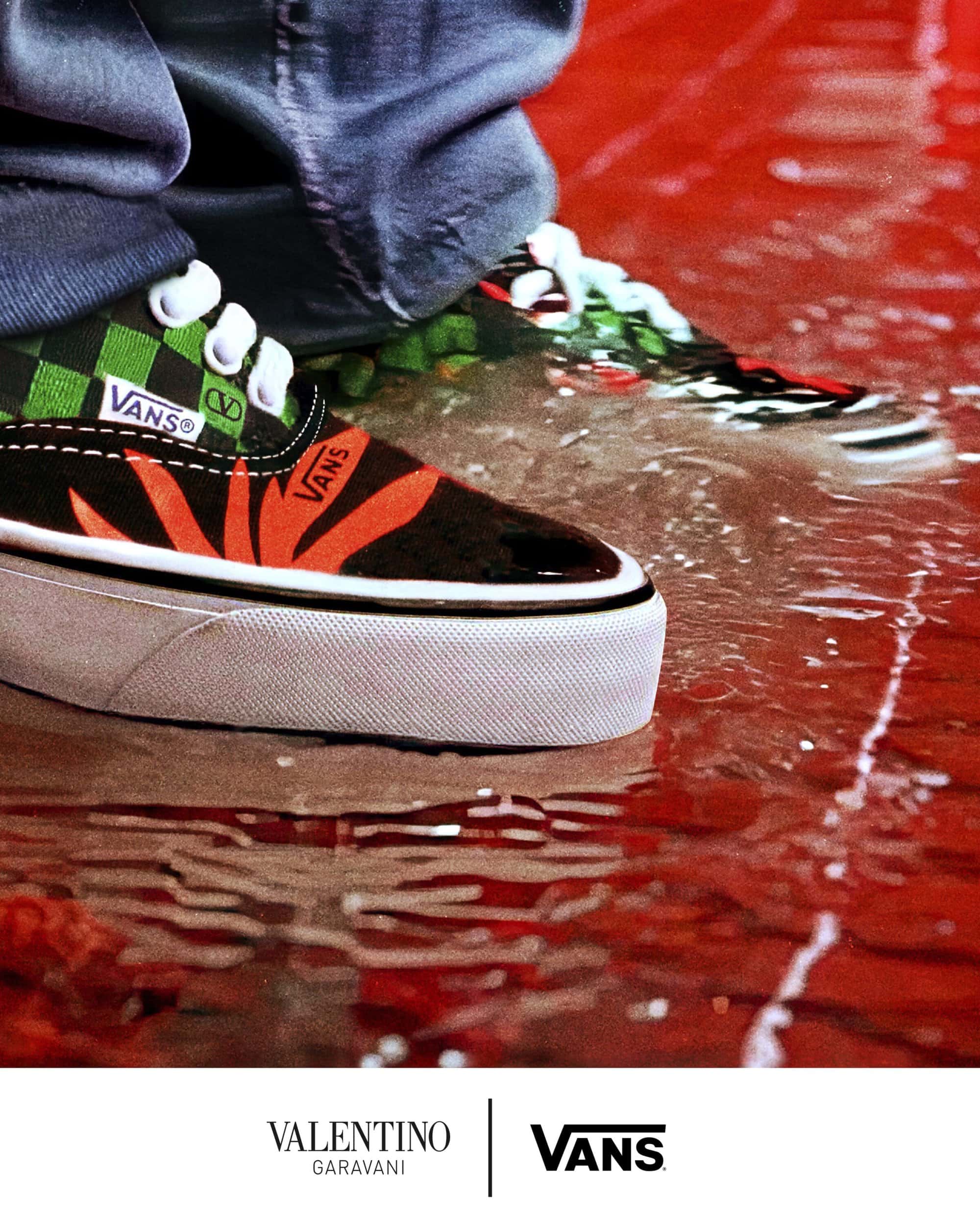 Close-up of Vans sneakers standing in a puddle on a red reflective surface with brand logos below