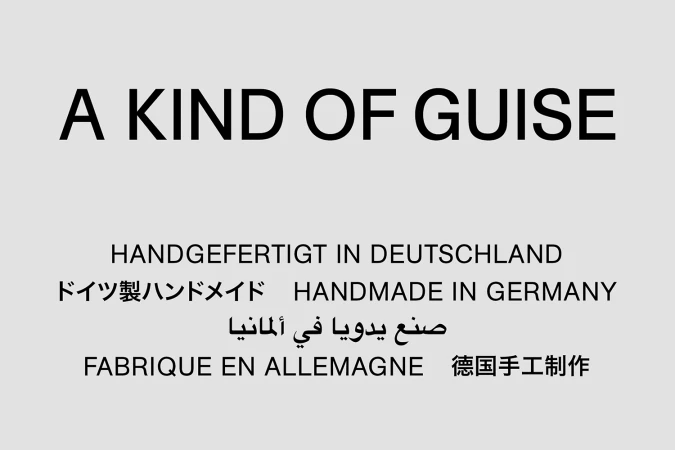 A Kind of Guise brand identity graphic with multilingual handmade in Germany text on grey background