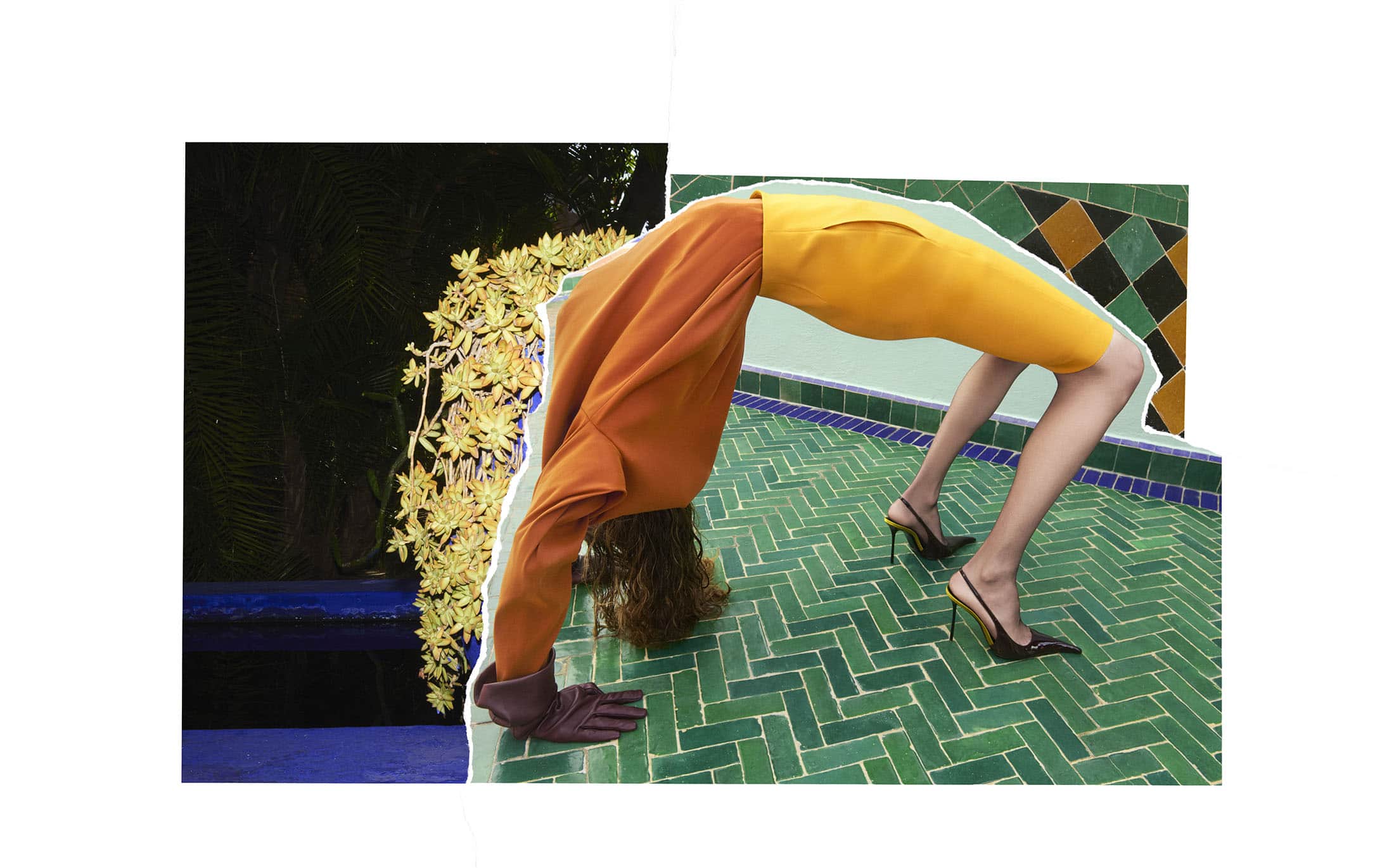 Model bending backwards in a backbend pose wearing an orange top, yellow skirt, and dark high heels on a green tiled patio