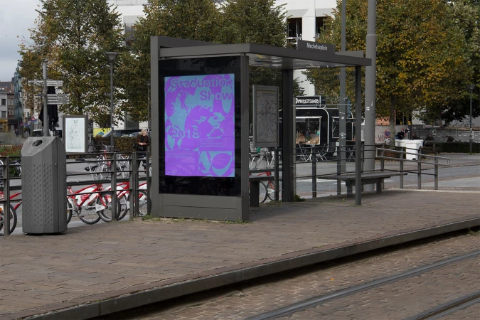 A bus shelter displaying a vibrant purple graduation show poster on an urban street platform