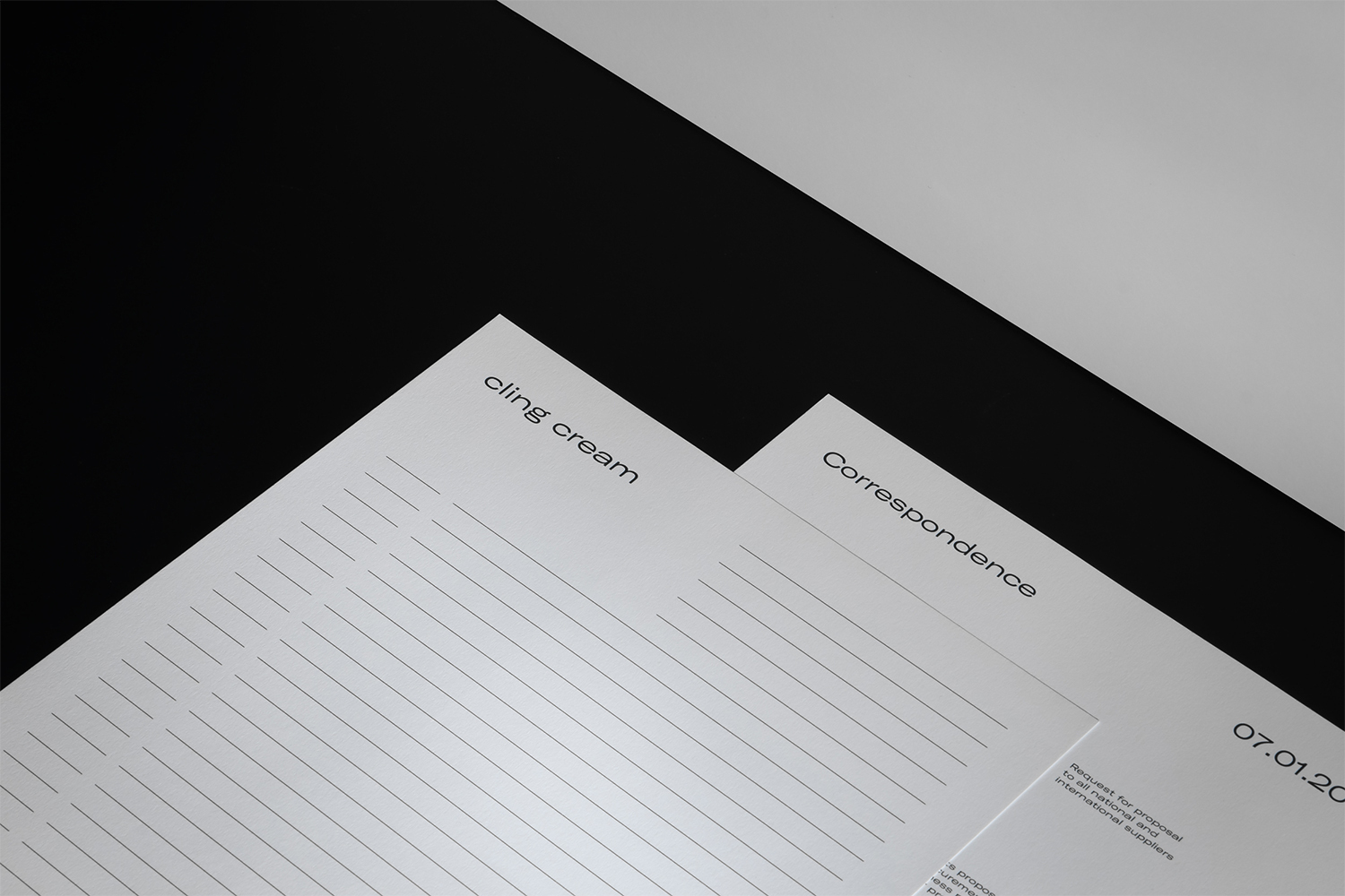 Minimalist graphic design stationery with lined paper and typography on a dark and light background