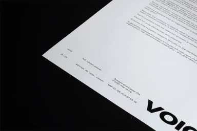 Printed document on white paper resting on a black surface showing minimalist typography and Void brand typography details.