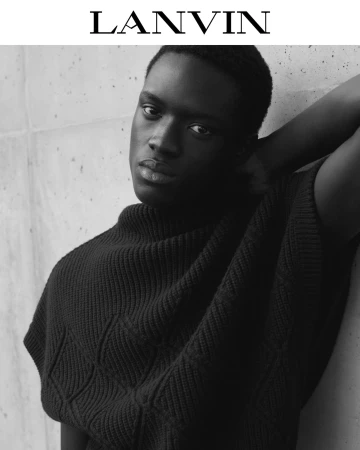 Black and white portrait of a black man wearing a textured knit top against a concrete background for Lanvin.