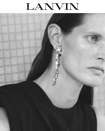 Close-up portrait of model Malgosia Bela wearing long crystal drop earrings and dark apparel for Lanvin Fall 2025.