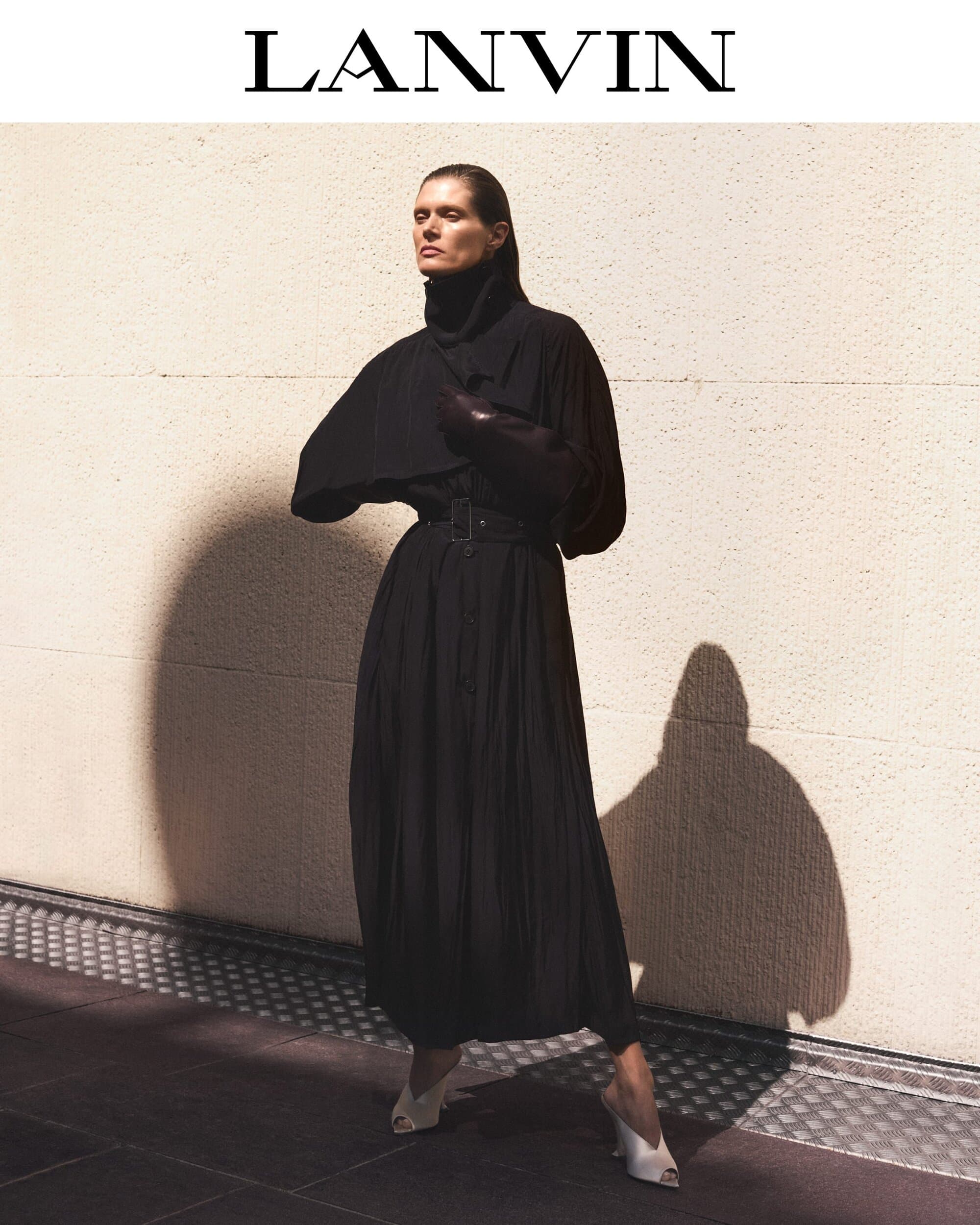 Model Malgosia Bela wearing a long black belted coat against a textured wall for Lanvin Fall 2025 Editorial Project