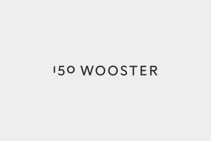 Minimalist graphic design showcasing the 150 Wooster brand identity logo in dark grey lettering centered on a pale grey background.