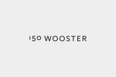 Minimalist graphic design showcasing the 150 Wooster brand identity logo in dark grey lettering centered on a pale grey background.