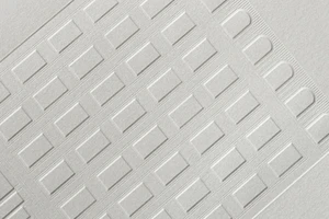 Close-up of a white textured paper with an embossed architectural grid and arched patterns designed by Javas Lehn Studio.