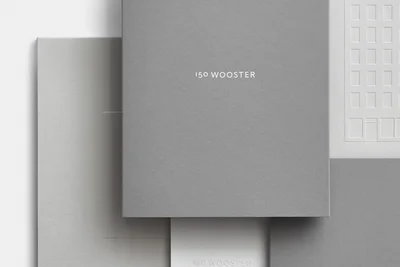 Minimalist grey and white stationery composition featuring debossed architectural illustrations and branding for 150 Wooster