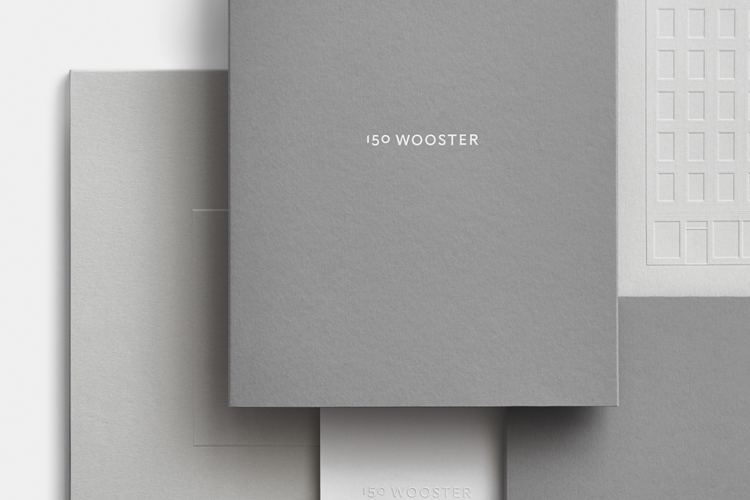 Minimalist grey and white stationery composition featuring debossed architectural illustrations and branding for 150 Wooster