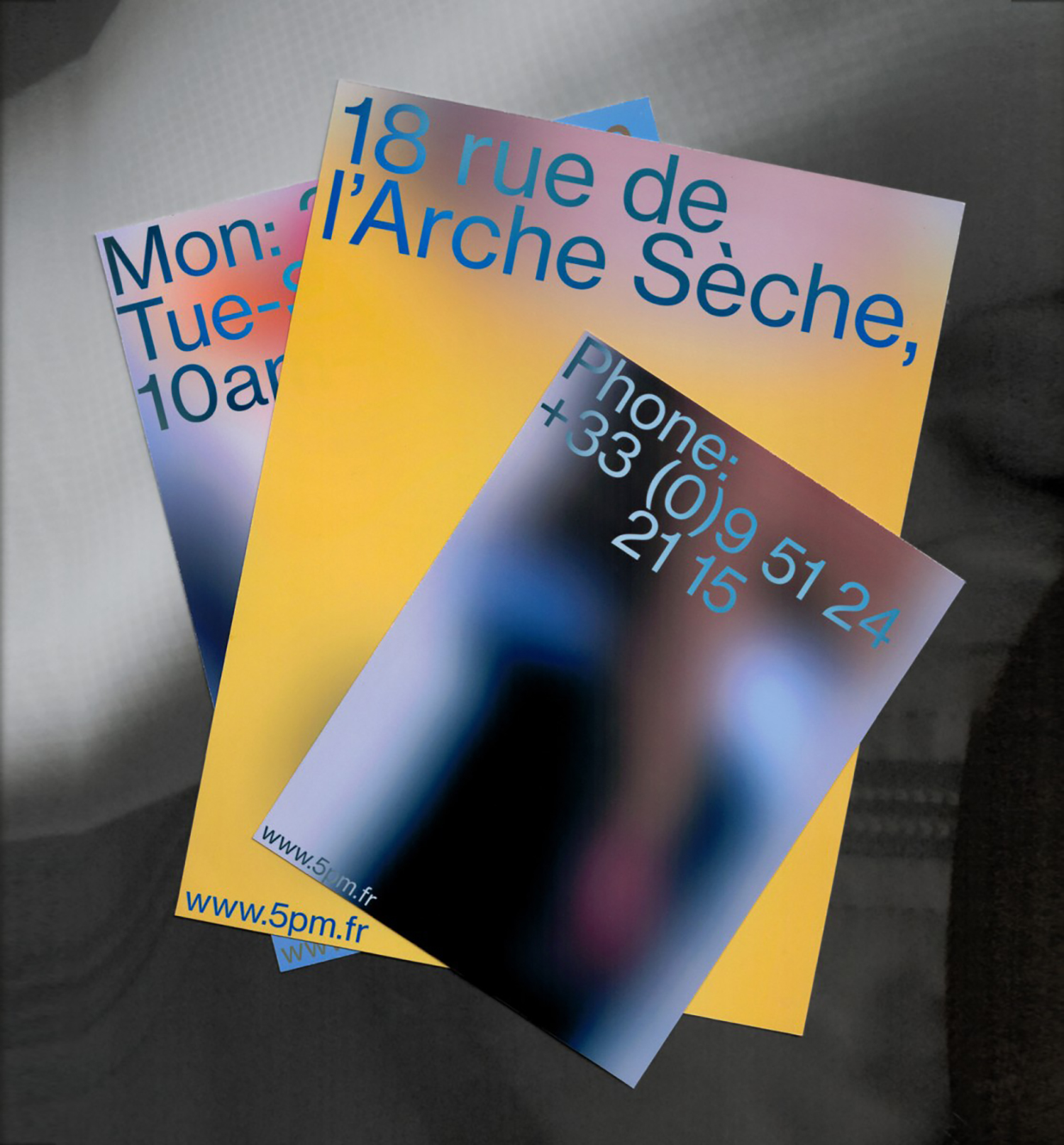 Stacked printed cards featuring gradient typography and address details for 5PM brand identity.