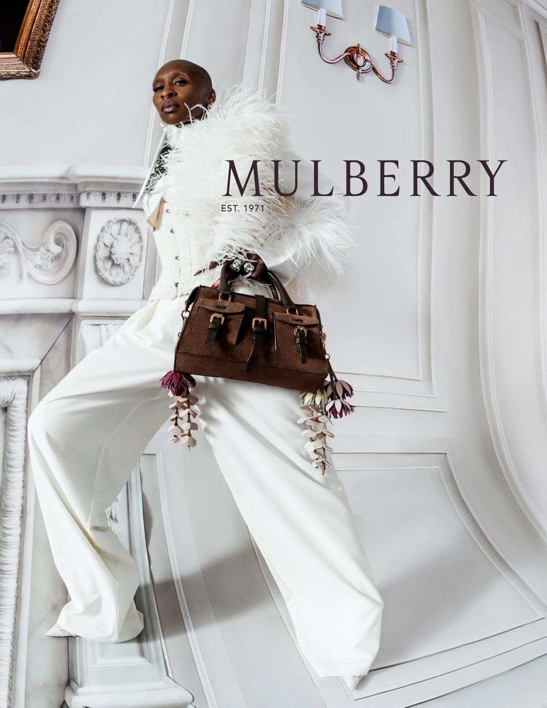 Cynthia Erivo wearing white attire with feathered trim and holding a brown leather handbag for Mulberry Spring 2026 ad campaign