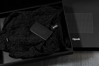 Black lace garment inside a black gift box with perforated brand tag by Deutsche und Japaner