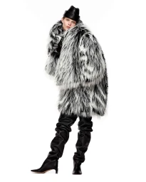 Model Ida Heiner wearing a voluminous black and white faux fur coat and thigh-high leather boots against a white backdrop.