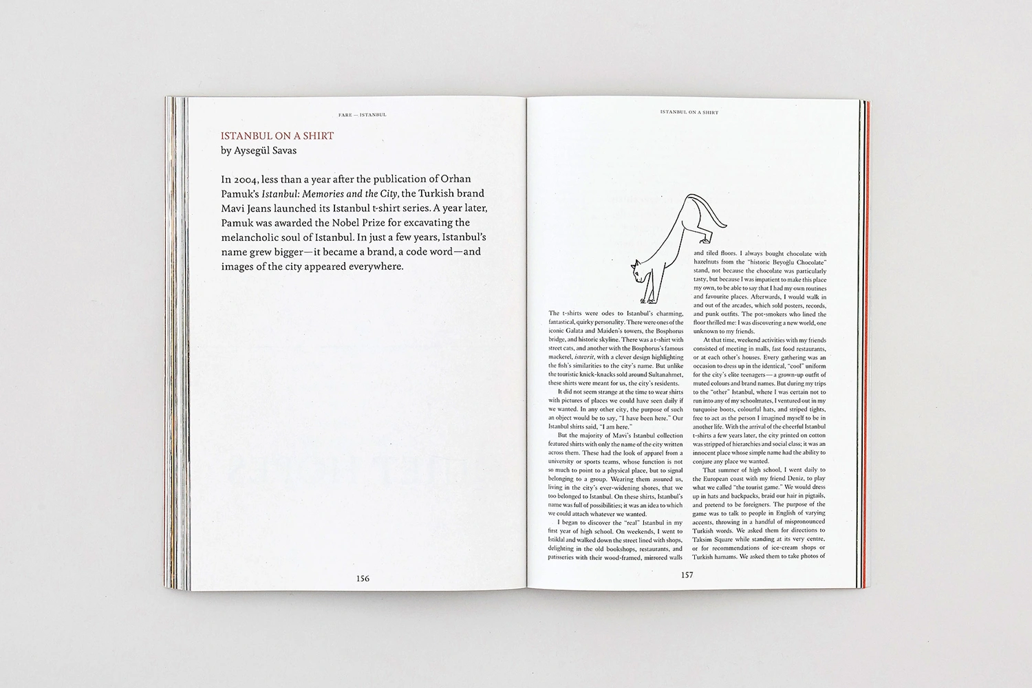 Open book spread showing two pages of printed text with a small line illustration of a cat on the right page.