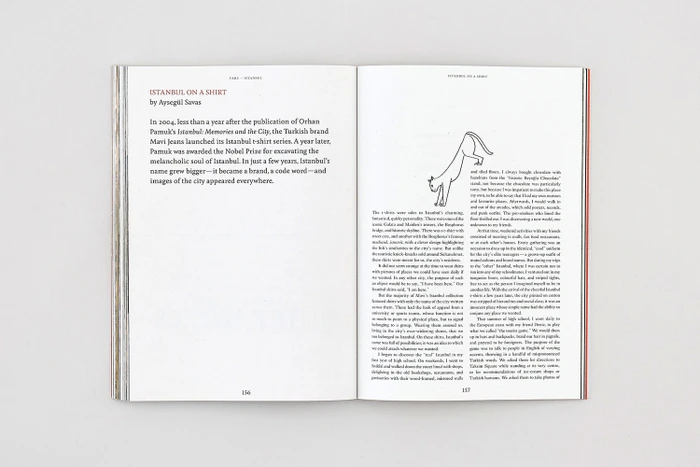 Open book spread showing two pages of printed text with a small line illustration of a cat on the right page.