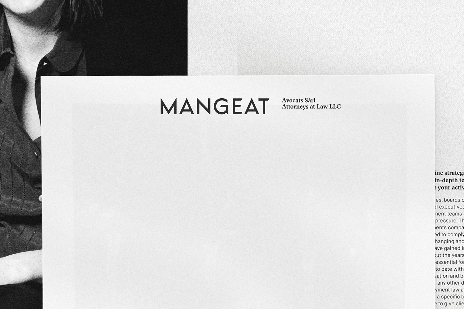 Black and white stationery mockup featuring the Mangeat attorneys at law logo on clean paper against a textured background.