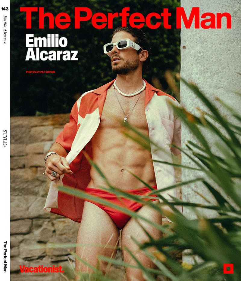 Magazine cover featuring a muscular man in a red swimsuit, sunglasses, and open shirt, posing outdoors with lush greenery.