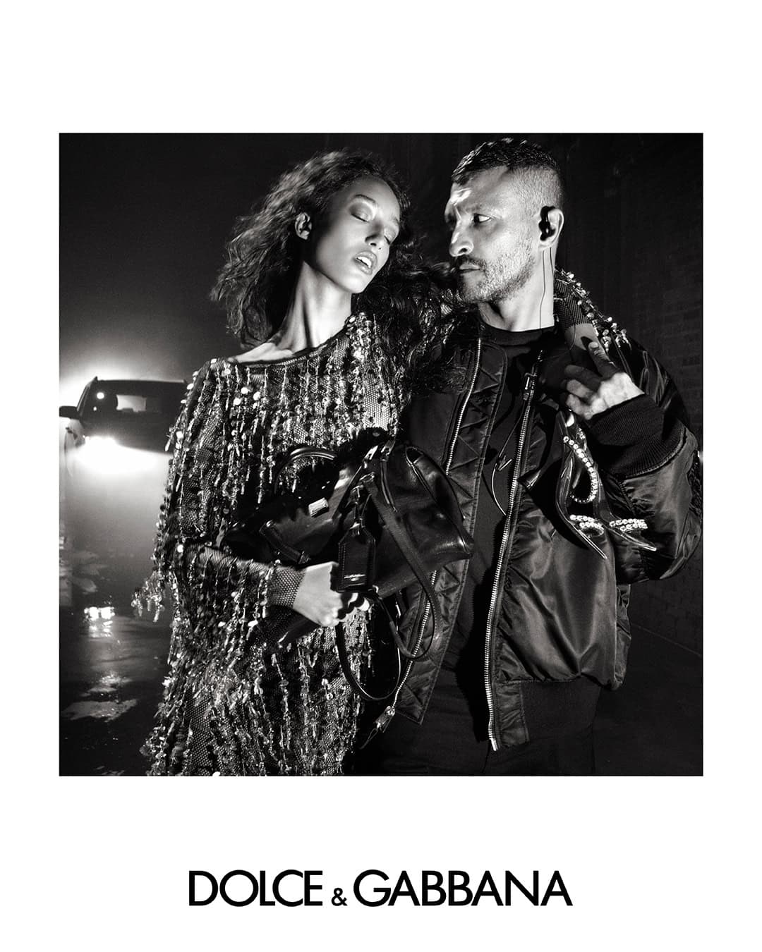 Black and white portrait of a woman in a sequined dress and a man in a bomber jacket for Dolce and Gabbana