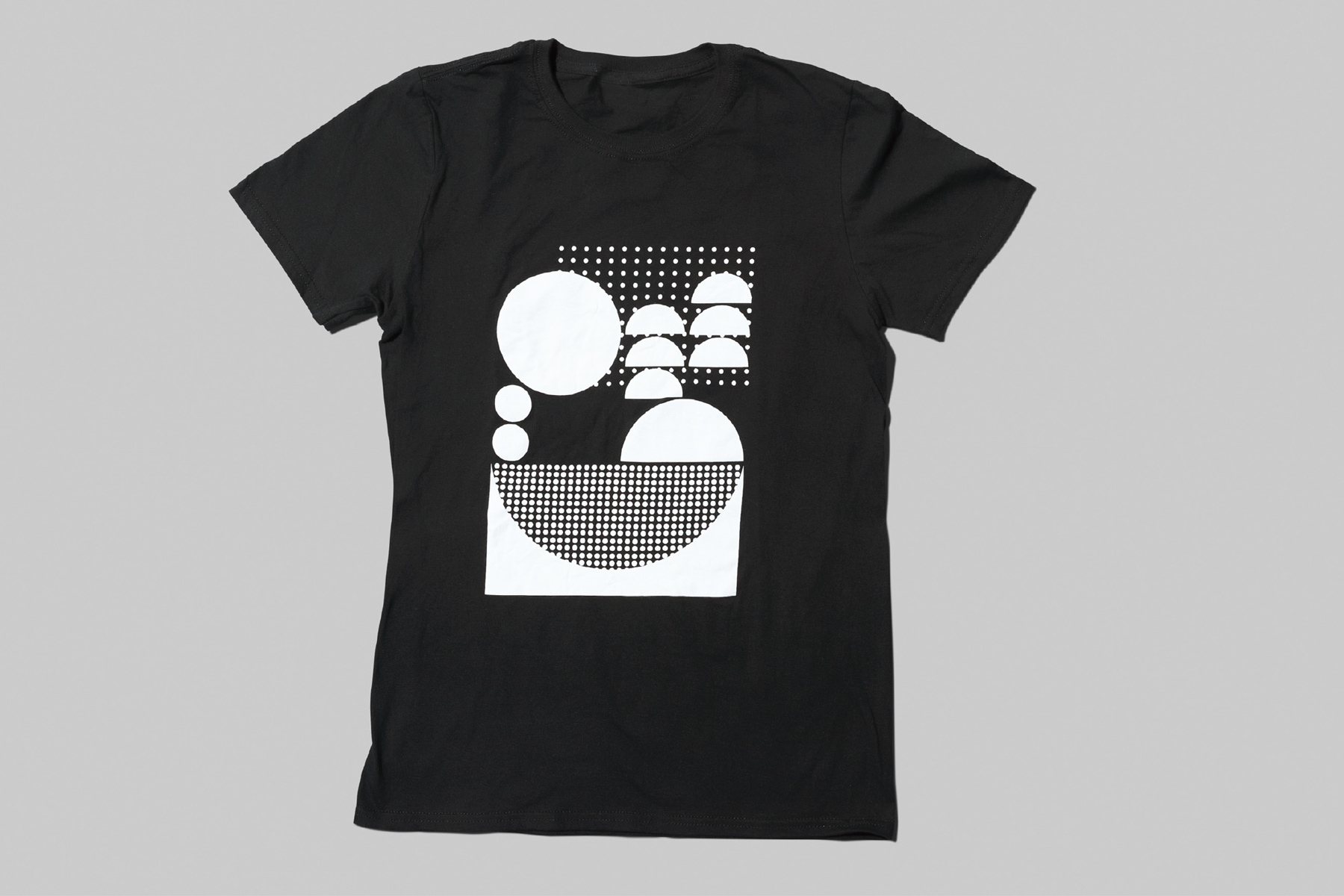 Black t-shirt featuring a white geometric graphic print centered on the chest against a grey background.