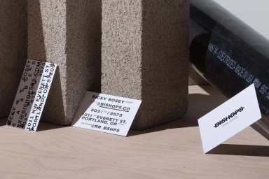 Bishops brand identity design featuring business cards and typography against concrete blocks and a dark pipe