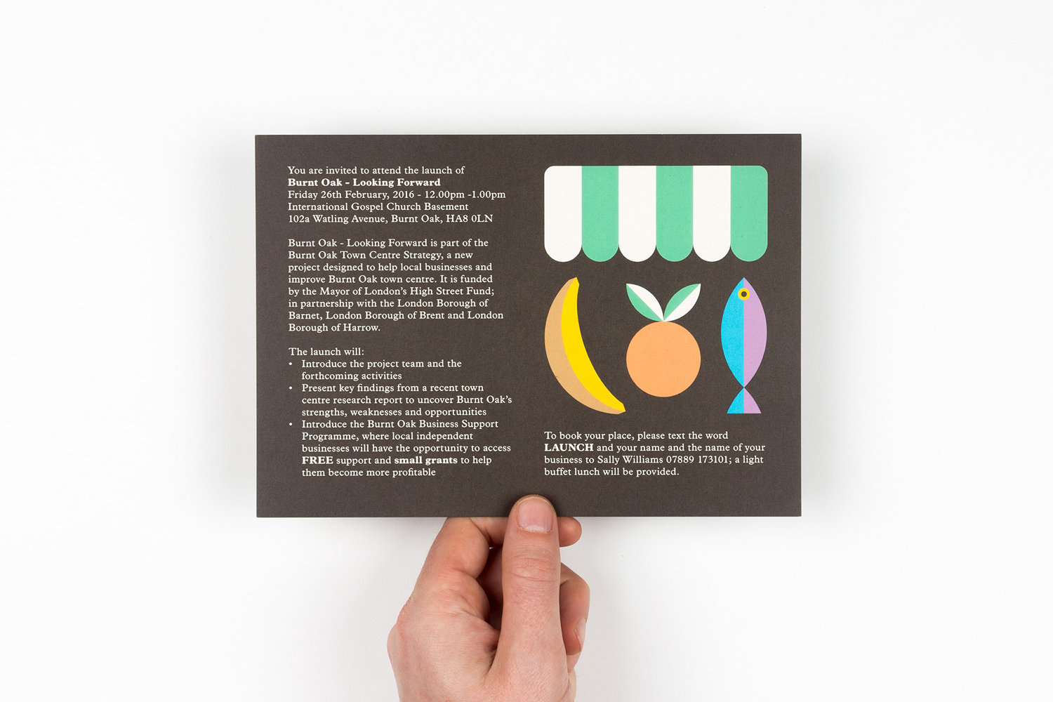 A hand holding a printed invitation card with dark grey background, typographic details, and colourful geometric illustrations.