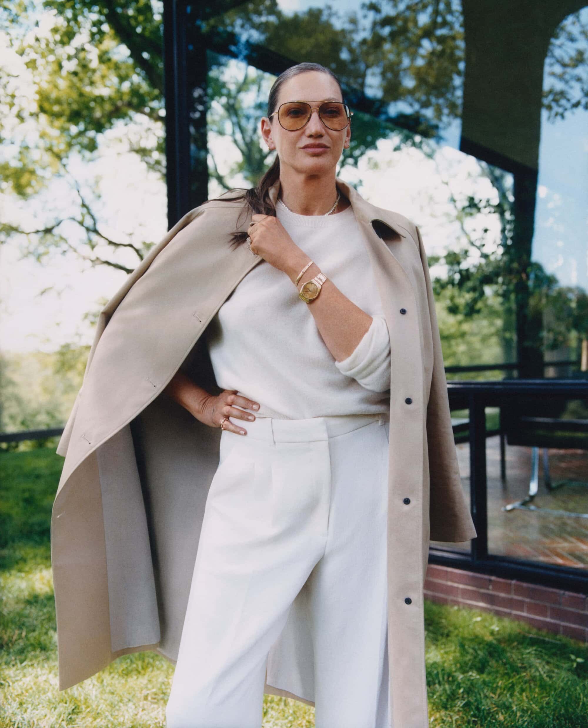 Jenna Lyons wearing a camel coat and white trousers outdoors for the Aritzia Fall 2025 campaign