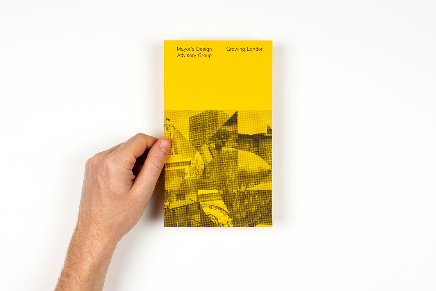 Hand holding a yellow publication brochure for the Mayor of London's Design Advisory Group against a white background
