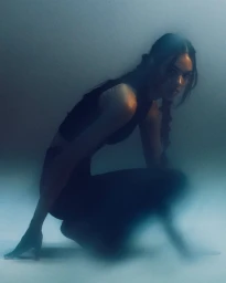 Model Grace Valentine in a dark outfit crouching in a misty studio setting for Stretch Your Story