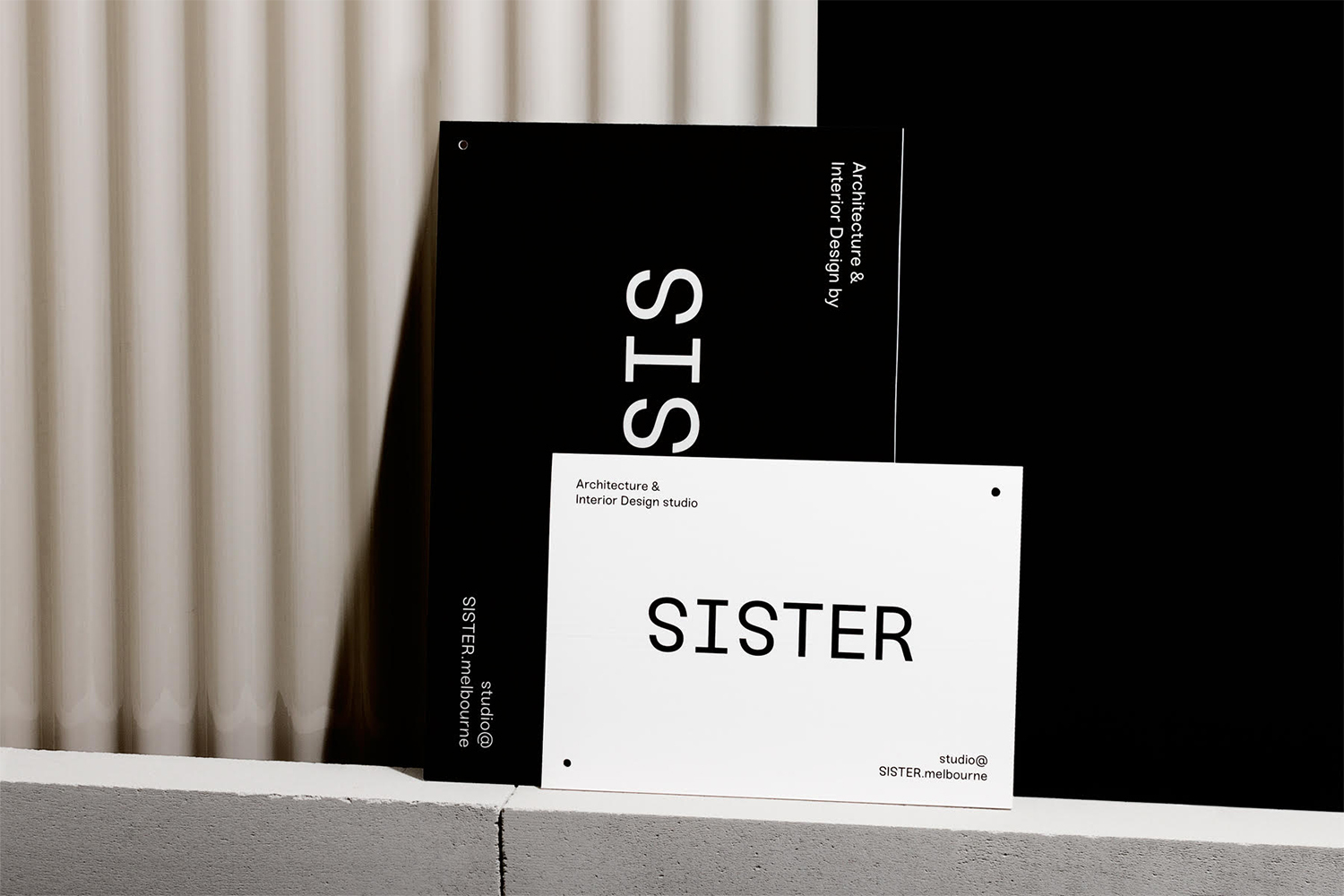 Monochrome brand identity presentation for Sister featuring stacked black and white printed cards displaying bold typography.