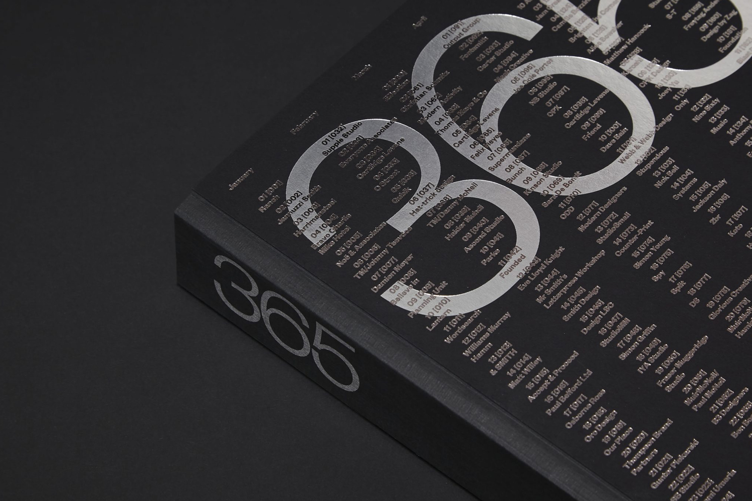 Close-up of a black bound book with metallic silver foil embossed typography and numbers reading 365 on cover and spine