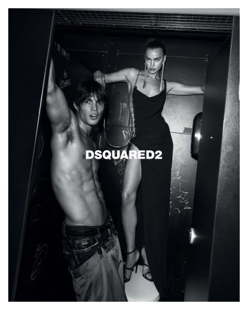 Black and white ad campaign image featuring Irina Shayk and a male model posed within a confined interior setting