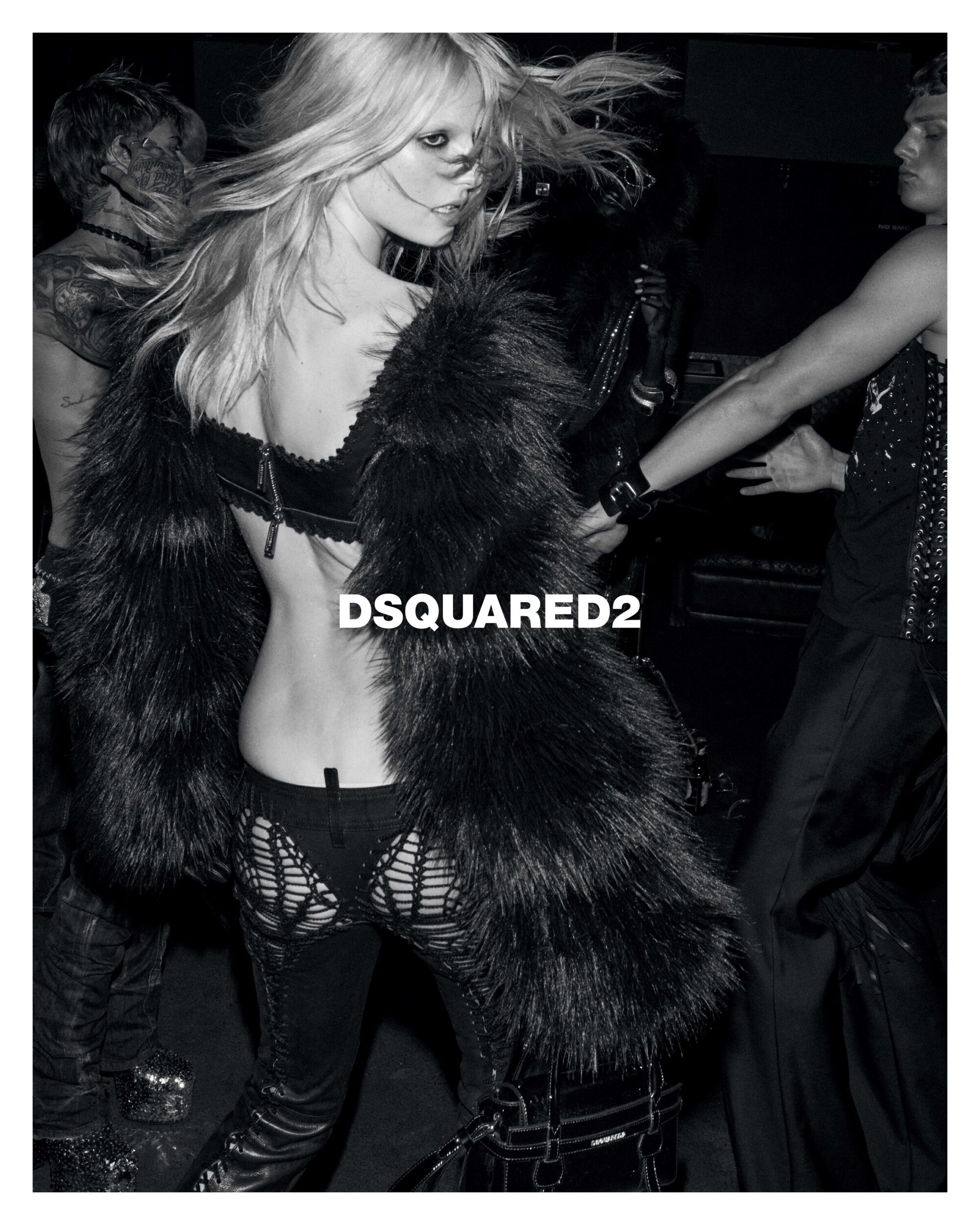 Monochrome fashion campaign image featuring a blonde model in a dark faux fur coat and cut-out trousers with Dsquared2 logo