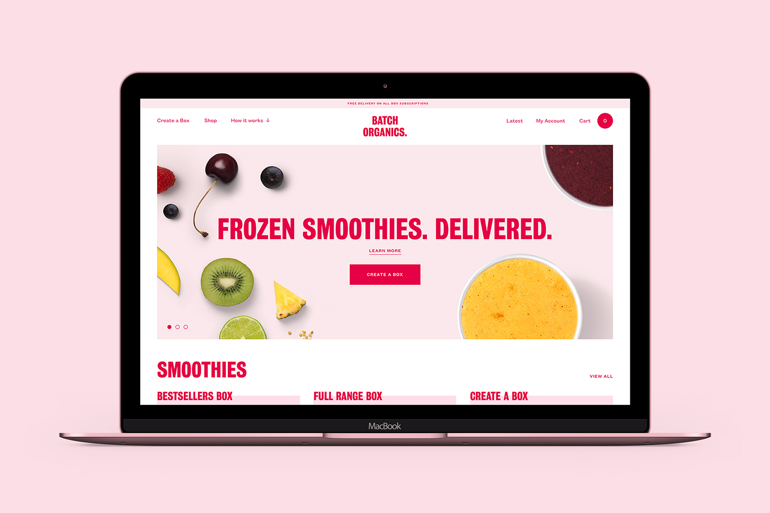 A laptop displaying the Batch Organics website with pink branding and fresh fruit imagery against a matching pink background.