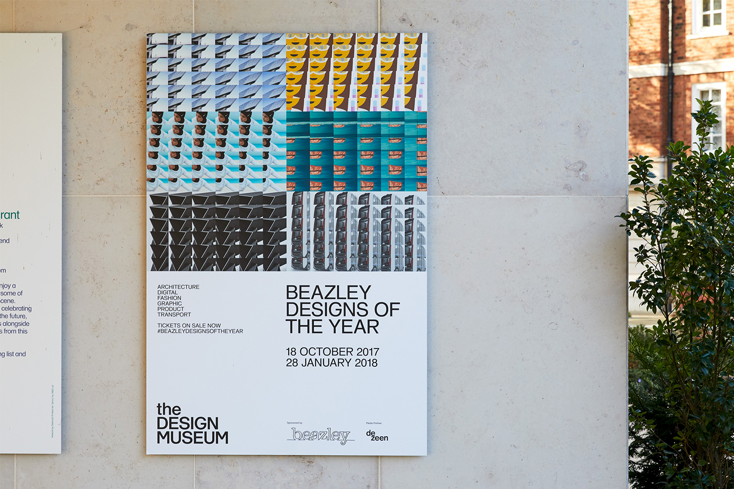 A poster for Beazley Designs of the Year mounted on an exterior stone wall, featuring a grid pattern graphic and bold typography.