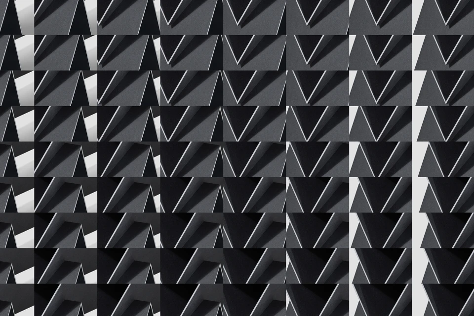 Monochrome geometric pattern featuring repeating triangular shapes and stark shadows creating a graphic architectural grid.