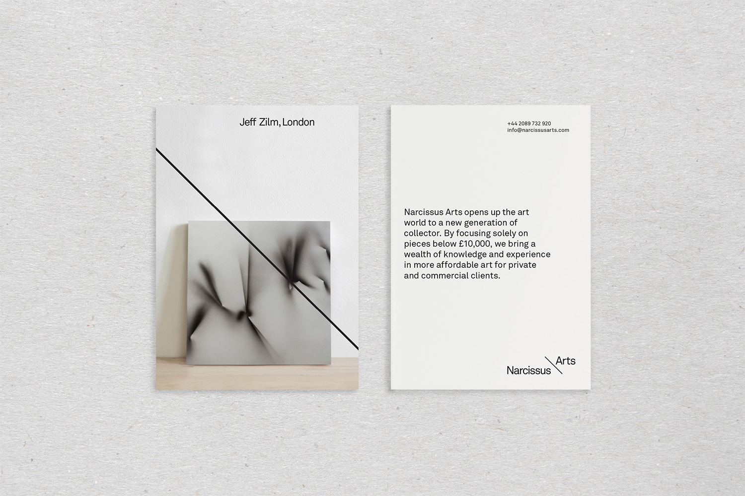 Two business cards for Narcissus Arts displayed on textured grey paper, featuring minimalist typography and diagonal line design.