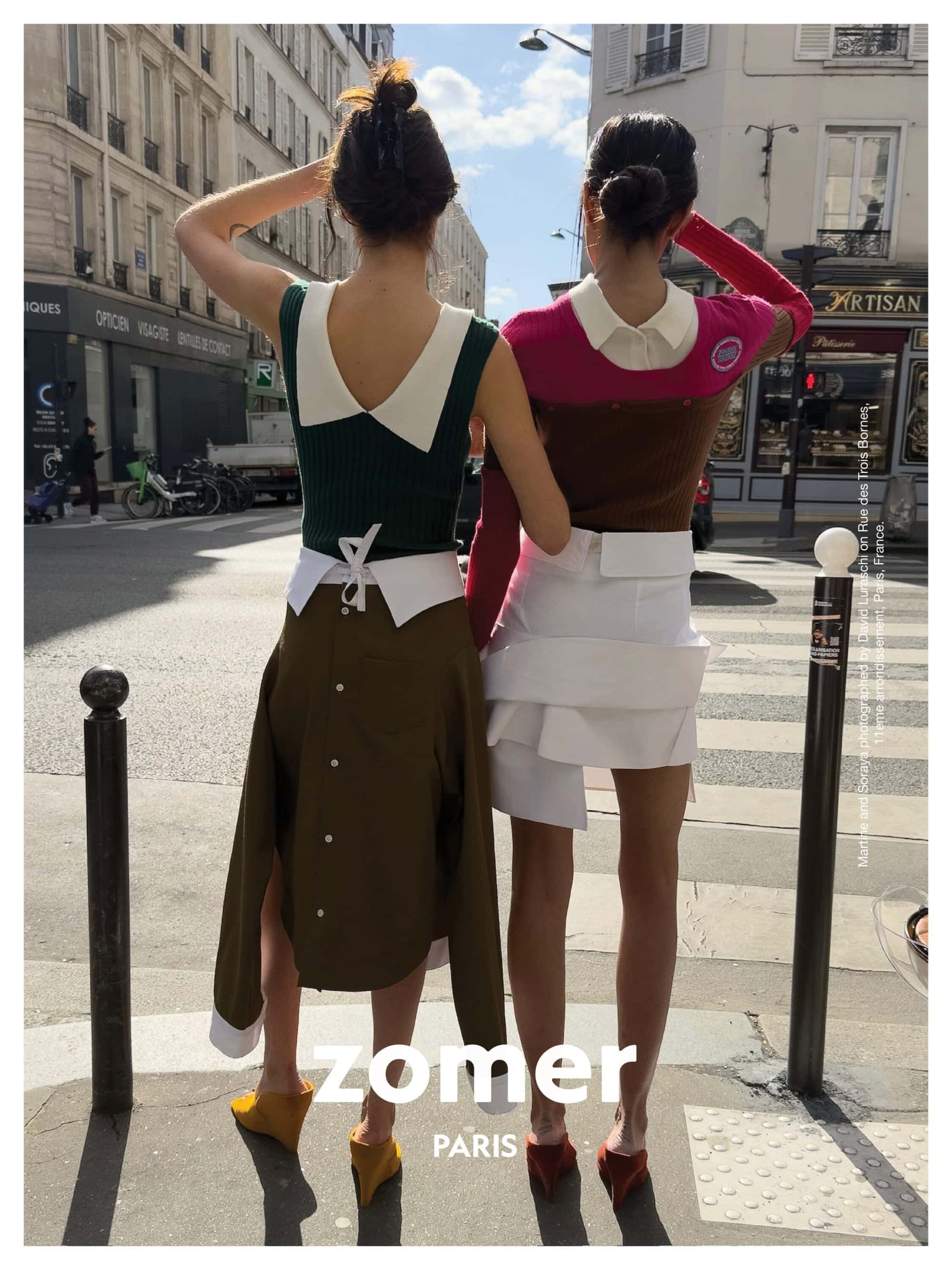 Two models standing on a Paris street wearing layered designer clothing and back-to-front garments, photographed by David Luraschi.