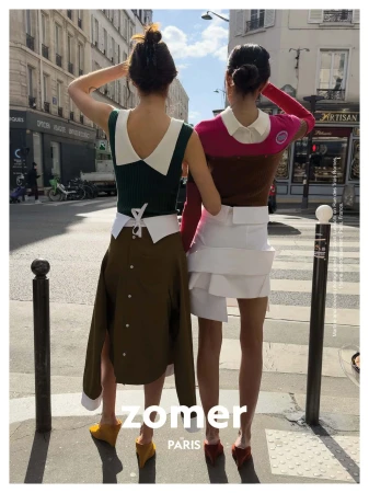 Two models standing on a Paris street wearing layered designer clothing and back-to-front garments, photographed by David Luraschi.